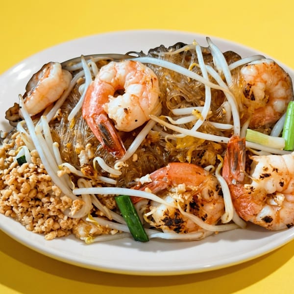 A close-up of Pad Woon Sen with shrimp, bean sprouts, and crushed peanuts on a white plate.